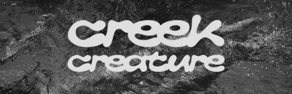 White stylized text reading 'creek creature' over a dark, textured water surface, with a small white logo above the text.